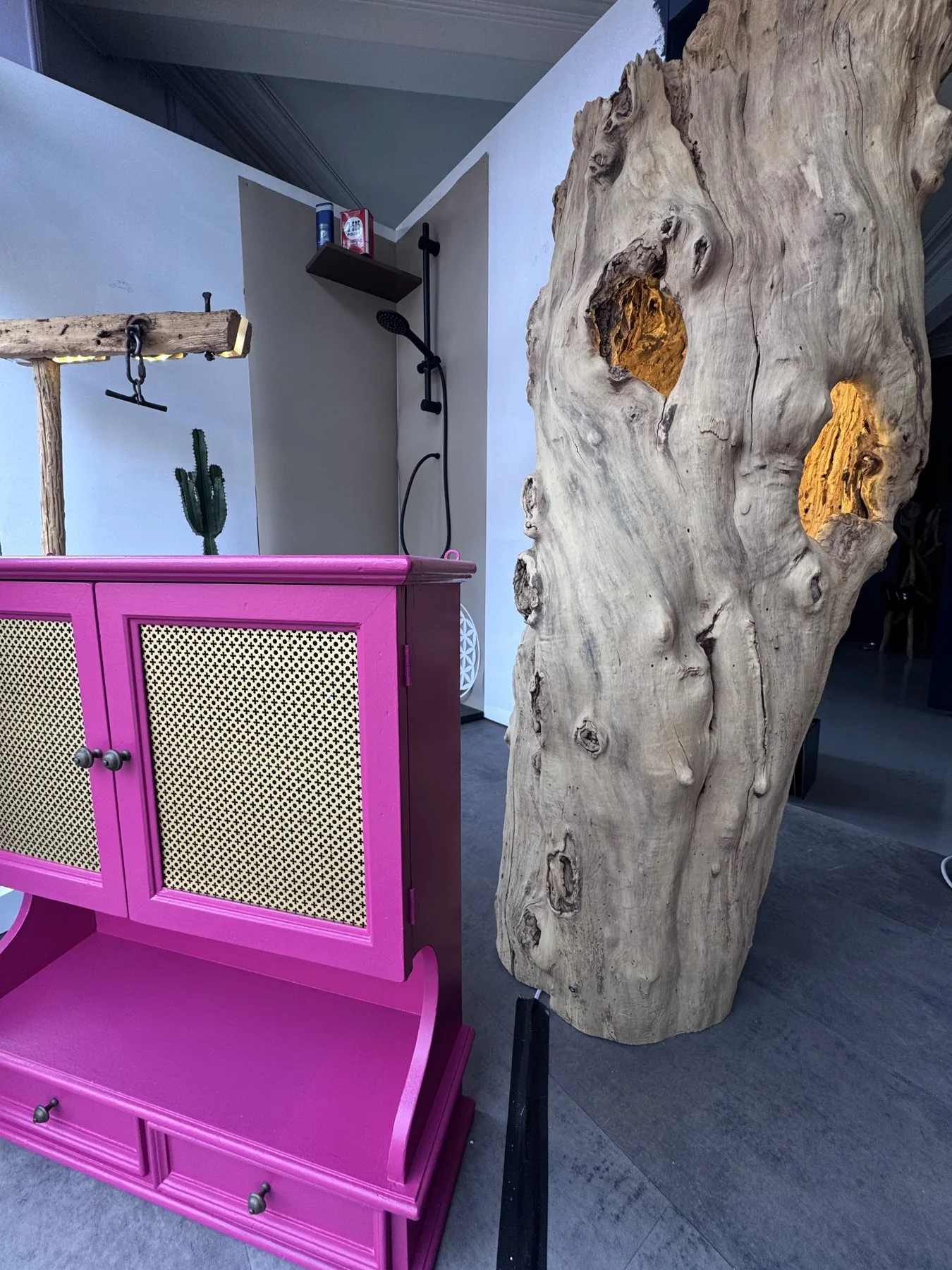 Détail de bois sculptural et mobilier rose au showroom